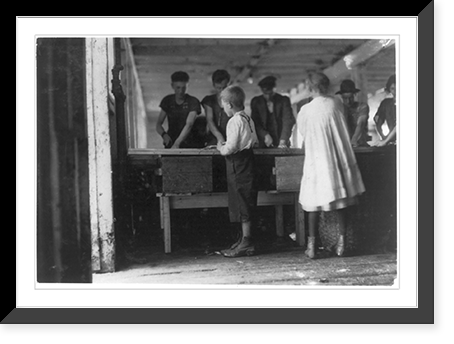 Interior of a cutting shed in Maine. Young cutters at work, Clarence, 8 years, and Minnie, 9 years. Photo does not show the salt water in which they often stand, not i.e., nor? the refuse they ha