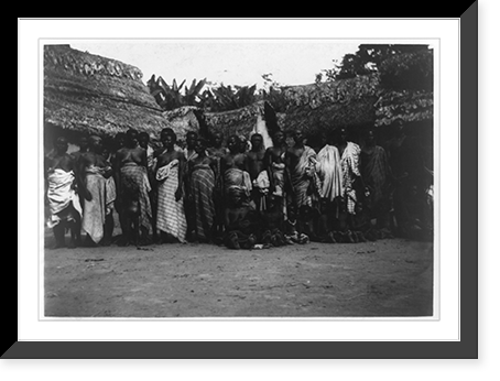 Group of Ashanti posed in front of huts, Kumasi, Gold Coast, Vintage Print