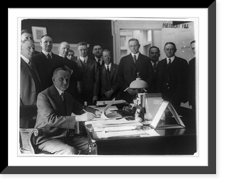 Calvin Coolidge seated at table signing bills, surrounded by group of men, Historic Print
