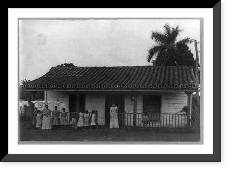Two women and nine children posed standing in front of house and laundry line, Cuba, Vintage Poster