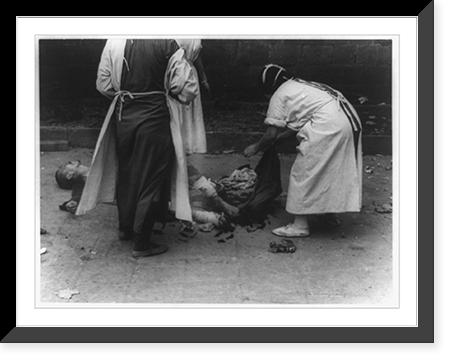 Medical personnel providing first aid on leg of injured man lying on pavement in China, after Japanese bombing, Antique Print
