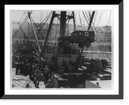 Mercy trucks accompany invaders; U.S. Coast Guardsmen load an ambulance aboard their transport at a North African port as they prepare to sail for Sicily, Vintage Print