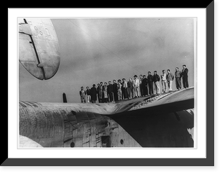 Test flight crew members for the Martin MARS airplane, posed standing on wing, Vintage Poster