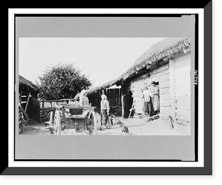 Two women standing in yard and other women and children standing in doorway of log structure, Russia - 2 Classic, Vintage Poster