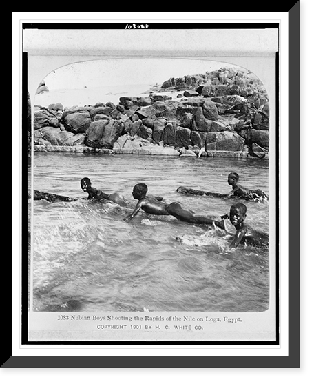 Nubian boys shooting the rapids of the Nile on logs, Egypt, Antique Print