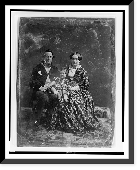 Unidentified man and woman, both about 30 years of age, with a child about two years of age seated on woman's knee, full-length portraits, facing front, seated on chairs on carpet Timeless Wall A
