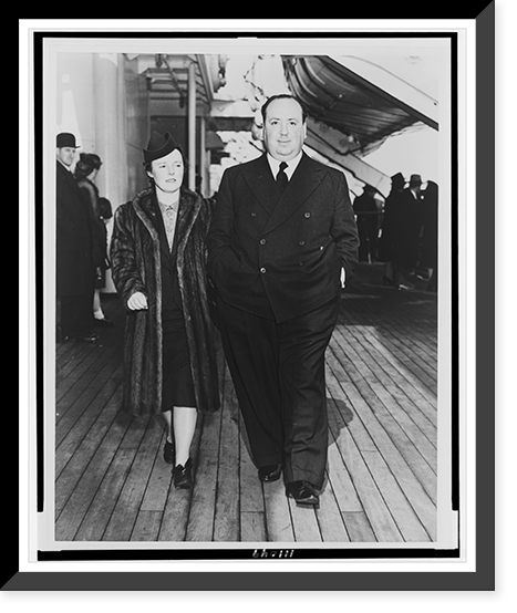 Alfred Hitchcock and his wife, Alma Reville, full-length portraits, walking on deck of the SS Queen Mary.Cosmo-Sileo Co. Classic, Vintage Print