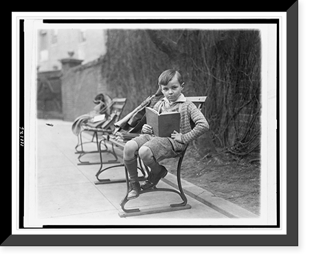 Unidentified boy, seated on park bench, probably in Washington, D.C., holding book, Historic Print