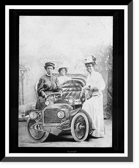 Three African-American women posed with studio prop automobile in photographer's studio, Vintage Poster