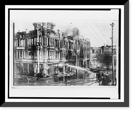 Block of burned buildings in San Francisco after the 1906 earthquake with fire truck spraying water on them, Vintage Poster