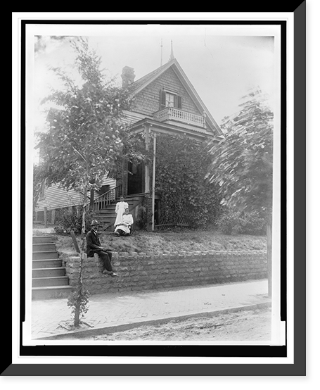 African American man seated on stone wall and two girls on lawn in front of house in Georgia, Antique Print