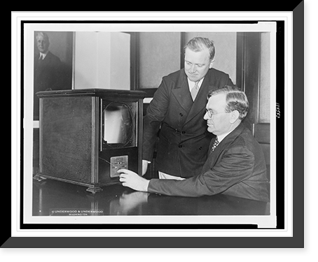 Secretary of Labor William N. Doak and his secretary, W.W. King, examining a television receiver in their office in Washington, D.C..photo by Underwood & Underwood, Antique Print