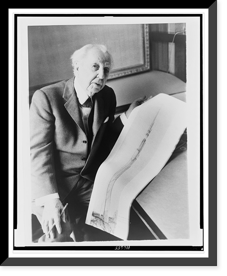 Frank Lloyd Wright, three-quarter length portrait, seated, facing front, holding sketch of a 528 story office building he designed, Antique Poster