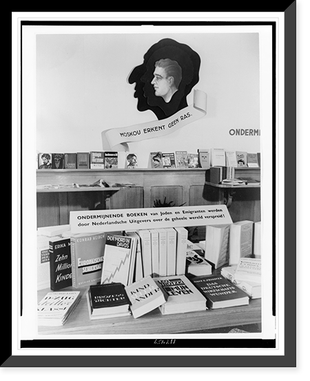 Exhibit of chiefly anti-communist and anti-Jewish propaganda, with books on table and shelves, The Hague, Netherlands, Antique Print