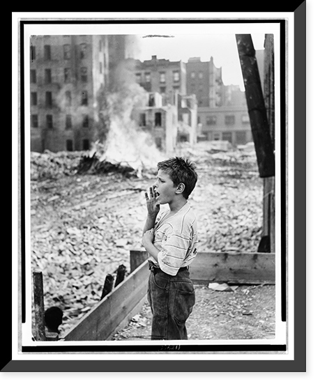 Boy yelling as he stands amid rubble of demolished slums, Vintage Poster