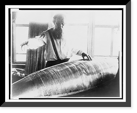 Konstantin Tsiolkovsky, half-length portrait, facing front, looking down at model of an early Russian rocket, Historic Print