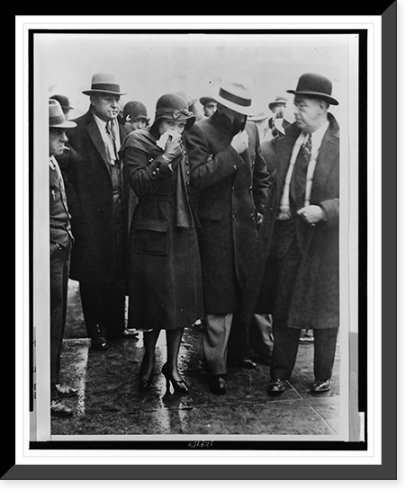 Mr. and Mrs. Vincent Coll, full-length portrait, walking through a crowd with their faces covered after being released from court, Historic Reproduction