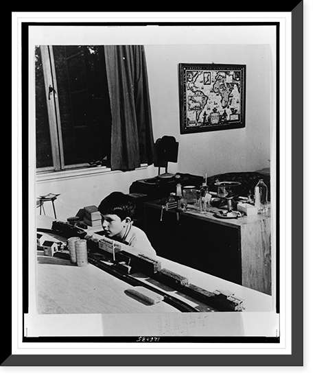 Thirteen-year-old boy playing with a model train in his bedroom, Greenbelt, Maryland, Antique Print