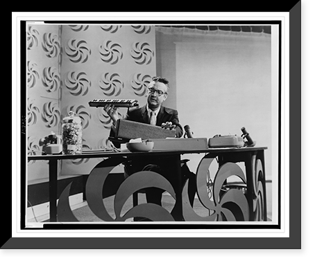 Steve Allen, full-length portrait, facing front, seated at table during his television program, Historic Reproduction