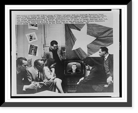 Group of Cuban refugees gather in a Manhattan Hotel room in front of television as President Kennedy announces a quarantine" of their home island during the Cuban Missile Crisis in 1962" Vintage