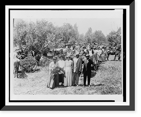 Portrait of three African American women and two men, behind them is a large group of African Americans in horse-drawn carriages and wagons in open area with trees on the left Heritage Wall Art P