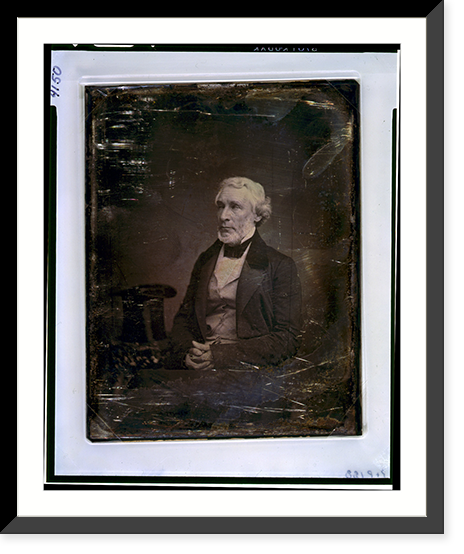 James Gordon Bennett, three-quarter length portrait, three-quarters to the left, seated, hands folded in lap, seated beside a small table with tablecloth on which rests a tall hat - 2 Timeless Wa