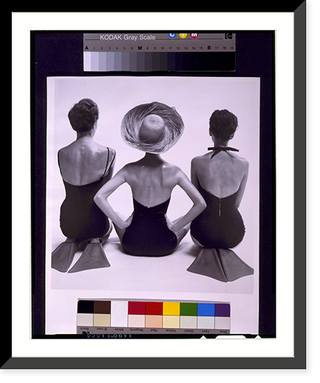 Back view of fashion models in swim suits, two kneeling wearing swim fins, and one seated, Vintage Print