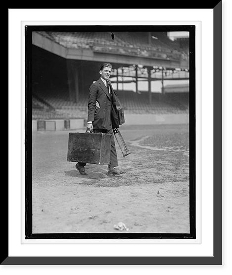 Man in suit carrying equipment cases in stadium Classic, Antique Print