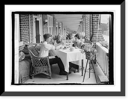 Man and woman eating at table on front porch of row house, Antique Poster