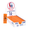 A display box of Zig-Zag Orange Rolling Papers 1¼, featuring 24 individual booklets. Each booklet contains 32 high-quality rolling papers made from natural flax plant fibers. The display box is designed for easy access, showcasing the classic Zig-Zag branding and emphasizing the 100% natural gum Arabic used for a perfect seal every time.