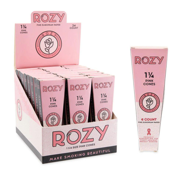 A 24ct display box of Rozy Pink 1 ¼ Size Pre-Rolled Cones, featuring individual 6-pack boxes. Each pack includes six bright pink pre-rolled cones with filter tips and a packing stick for easy filling. The display box is designed to attract attention with its vibrant pink packaging and distinctive rose logo, making it stand out on any retail shelf and appealing to customers looking for a stylish and meaningful smoking accessory.