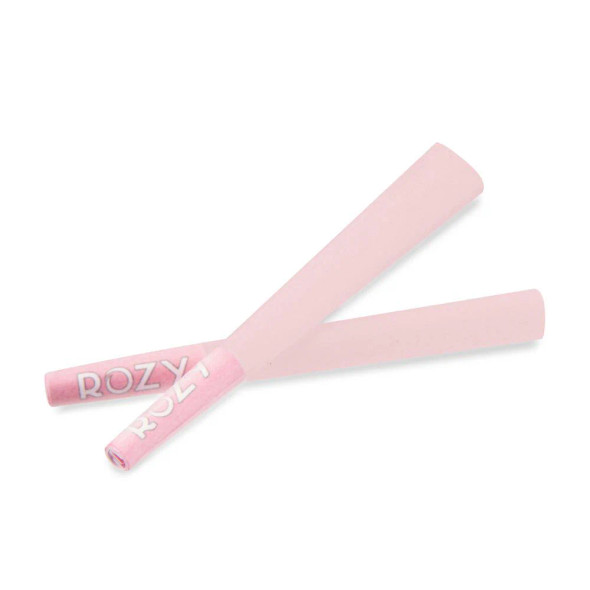 A close-up view of individual Rozy Pink 1 ¼ Size Pre-Rolled Cones from the 50-count tub, featuring the smooth, even texture of the cones with filter tips included. The bright pink color and rose logo emphasize the product's unique appeal and charitable purpose, perfect for personal use or as a thoughtful gift.