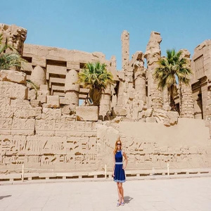 Carved stone columns and palms at Karnak Temple, Luxor, Egypt