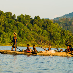 Local Sepik villagers travelling by traditional motorised dugout canoe along the Sepik River, Papua New Guinea