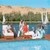 Guests relaxing on a Nile cruise deck as feluccas pass, Egypt