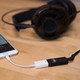 AudioQuest DragonFly Black — connected to iPhone via Lightning adapter with headphones