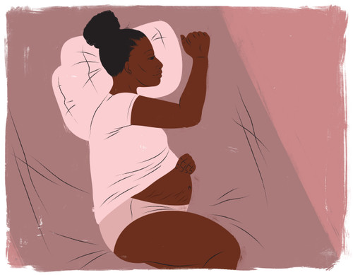 Pregnant woman in bed holding belly