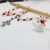 Chicken and scarecrow row counter with colourful beads for an eye catching row counter chain. Displayed over a bamboo knitting needle.