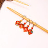 This set includes a mix of beaded stitch markers featuring vibrant orange millefiori flowers and adorable hearts.
