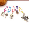 Alice in Wonderland row counter chain on knitting needle with colourful bulb pin stitch markers featuring Once Upon a Time book, owl key, playing cards, teapot and White Rabbit charms