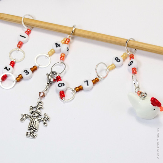 Chicken and scarecrow row counter with colourful beads for an eye catching row counter chain. Displayed over a bamboo knitting needle.