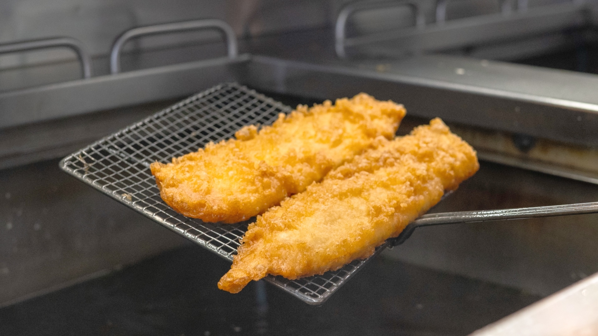 Fish being fried in a commercial kitchen
