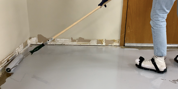 applying epoxy flooring to edges of room