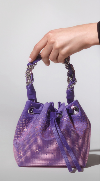 Hand holding a crystal-embellished handbag
