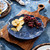Juliska Le Panier Mystic Knot Charger/Platter - Denim

KHM09/46
14"D

Symbolizing protection, love, and a long, happy life, the mystic knot has been cherished for generations by sailors as a tribute to their families and the sea. With its interwoven braided whorls in a deep denim blue hue, this large charger delivers rich textural warmth, a sculptural silhouette, and a timeless aesthetic to the table for layering with other patterns or for use as a beautiful serving platter.