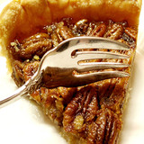 Slice of pecan pie with a fork on a white plate — scent inspiration for Butter Pecan Pie fragrance oil