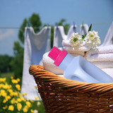 Detergent bottle and towels in a basket by a laundry line — scent inspiration for Downy April Fresh fragrance oil