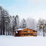 Wooden lodge in snowy forest under pale blue sky — scent inspiration for Ski Lodge fragrance oil