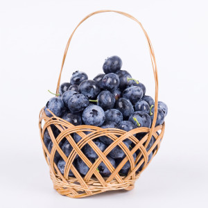Blueberries in a woven wicker basket on white — scent inspiration for Blueberry fragrance oil