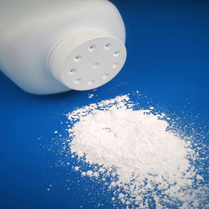 White powder spilling from talc bottle on blue surface — scent inspiration for Baby Powder fragrance oil